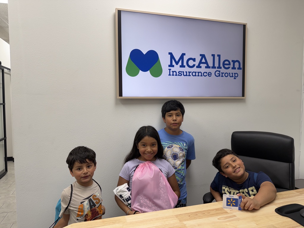 Kids picking up backpacks at the office giveaway